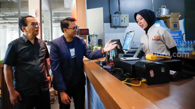Chief of Product OttoDigital Group, Murti Daryandono bersama General Manager PT Boga Suryo Buwono, Sukotjo saat mencoba aplikasi pembayaran usai jumpa pers di Bakso Lapangan Tembak Senayan, Jakarta, Rabu (22/4/2026). [Suara.com/Alfian Winanto]