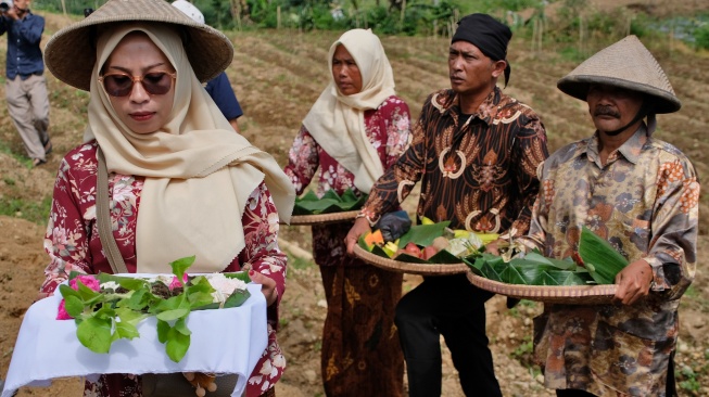 Sejumlah petani membawa berbagai macam sesaji saat tradisi Wiwit Tanam Tembakau di perladangan kawasan lereng Gunung Sumbing, Desa Wonosari, Bulu, Temanggung, Jawa Tengah, Jumat (24/4/2026). [FOTO ANTARA/Anis Efizudin/YU]