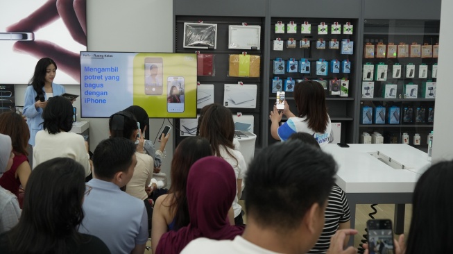 Pengunjung mencoba iphone saat gelaran Helloversary di Jakarta, Sabtu, (25/4/2026). [Suara.com/Alfian Winanto]