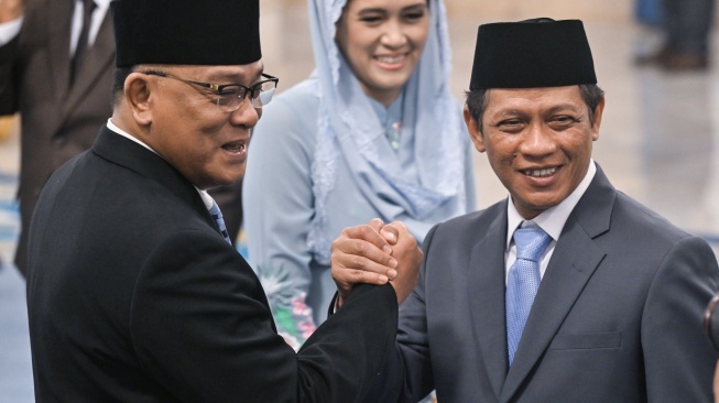 Menteri Lingkungan Hidup Jumhur Hidayat (kiri) dan Wakil Menteri Koordinator Bidang Pangan Hanif Faisol (kanan) berjabat tangan usai dilantik Presiden Prabowo Subianto di Istana Negara, Jakarta, Senin (27/4/2026). [ANTARA FOTO/Bayu Pratama S/app/tom]