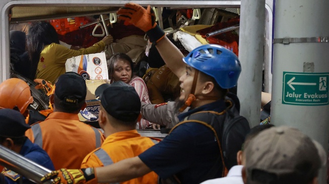 Petugas mengevakuasi korban yang masih terjebak di dalam gerbong KRL Commuterline yang bertabrakan dengan KA Argo Bromo Anggrek relasi Gambir-Surabaya Pasar Turi di Stasiun Bekasi Timur, Bekasi, Jawa Barat, Senin (27/4/2026). [ANTARA FOTO/Dhemas Reviyanto/app]