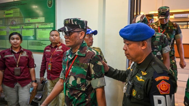 Terdakwa kasus penyiraman air keras kepada aktivis KontraS Andrie Yunus, Serda Edi Sudarko (kiri) berjalan keluar usai menjalani sidang pembacaan dakwaan di Pengadilan Militer II-08, Jakarta, Rabu (29/4/2026). [ANTARA FOTO/Fauzan/tom]