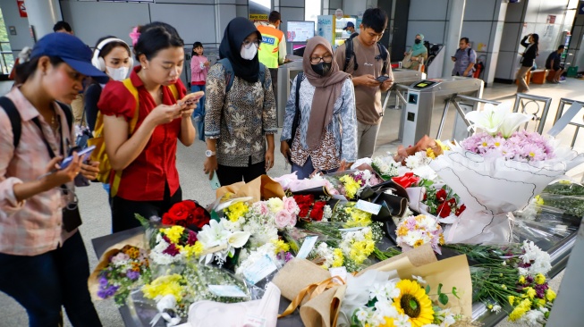 Warga berdoa di depan karangan bunga yang diletakkan di salah satu sudut Stasiun Bekasi Timur, Bekasi, Jawa Barat, Kamis (30/4/2026). [Suara.com/Alfian Winanto]
