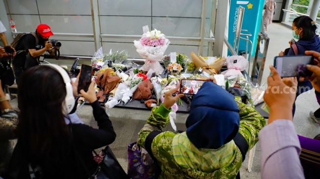 Warga berdoa di depan karangan bunga yang diletakkan di salah satu sudut Stasiun Bekasi Timur, Bekasi, Jawa Barat, Kamis (30/4/2026). [Suara.com/Alfian Winanto]
