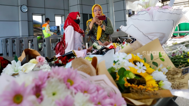 Warga berdoa di depan karangan bunga yang diletakkan di salah satu sudut Stasiun Bekasi Timur, Bekasi, Jawa Barat, Kamis (30/4/2026). [Suara.com/Alfian Winanto]
