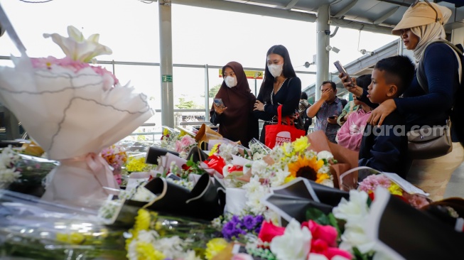 Warga berdoa di depan karangan bunga yang diletakkan di salah satu sudut Stasiun Bekasi Timur, Bekasi, Jawa Barat, Kamis (30/4/2026). [Suara.com/Alfian Winanto]
