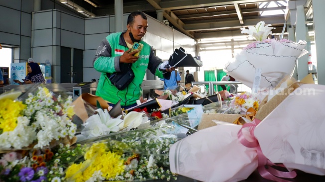 Warga berdoa di depan karangan bunga yang diletakkan di salah satu sudut Stasiun Bekasi Timur, Bekasi, Jawa Barat, Kamis (30/4/2026). [Suara.com/Alfian Winanto]
