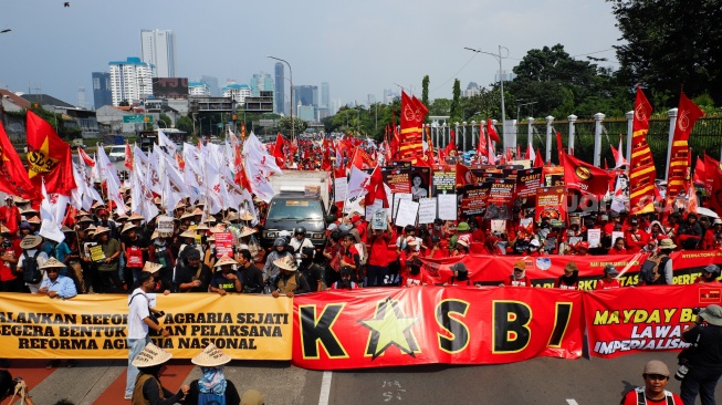 Massa dari berbagai elemen masyarakat dan buruh membawa poster pada aksi memperingati Hari Buruh Internasional atau May Day 2026 di depan gedung DPR RI, Jakarta, Jumat (1/5/2026). [Suara.com/Alfian Winanto]
