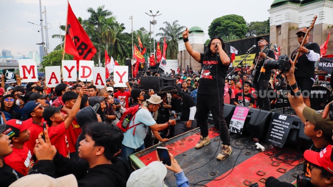 Band No End tampil saat mengikuti aksi memperingati Hari Buruh Internasional atau May Day 2026 di depan gedung DPR RI, Jakarta, Jumat (1/5/2026). [Suara.com/Alfian Winanto]