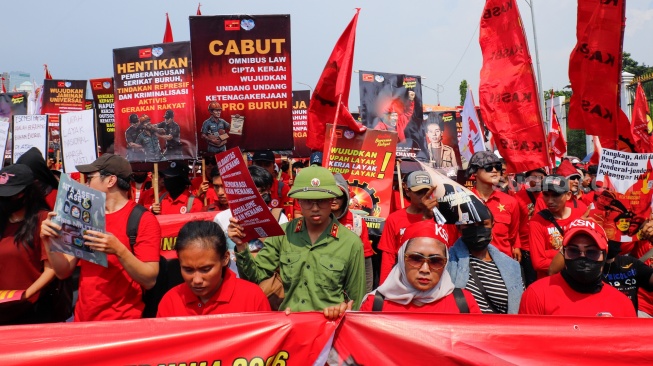 Massa dari berbagai elemen masyarakat dan buruh membawa poster pada aksi memperingati Hari Buruh Internasional atau May Day 2026 di depan gedung DPR RI, Jakarta, Jumat (1/5/2026). [Suara.com/Alfian Winanto]
