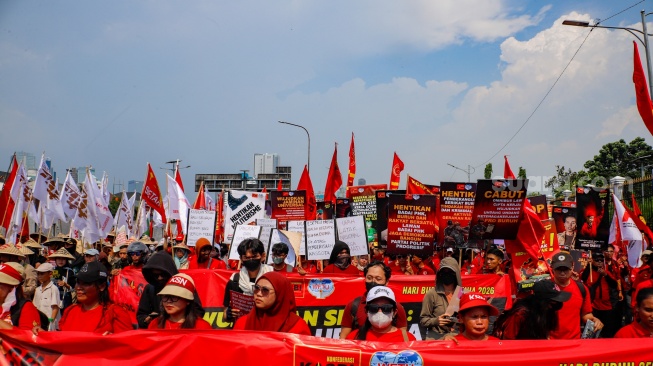 Massa dari berbagai elemen masyarakat dan buruh membawa poster pada aksi memperingati Hari Buruh Internasional atau May Day 2026 di depan gedung DPR RI, Jakarta, Jumat (1/5/2026). [Suara.com/Alfian Winanto]
