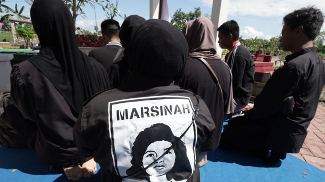 Sejumlah buruh memanjatkan doa di makam pahlawan nasional Marsinah di Desa Nglundo, Kabupaten Nganjuk, Jawa Timur, Jumat (1/5/2026). [ANTARA FOTO/Prasetia Fauzani/nz]