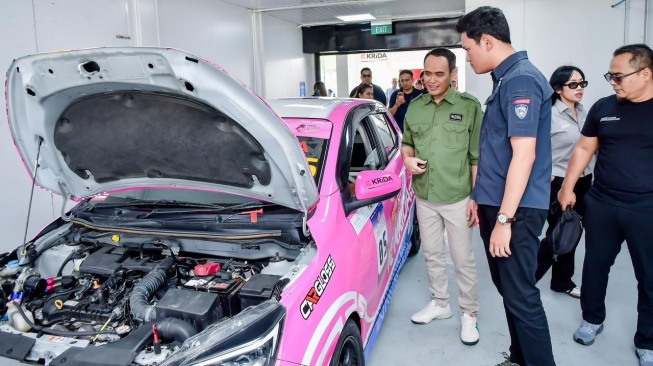 Pemimpin Wilayah PT Pegadaian Kanwil VII Denpasar, Edy Purwanto menilik racing car yang terjun di kompetisi internasional GT World Challenge Asia, Mandalika Kartini Race 2026. (Dok: PT Pegadaian)