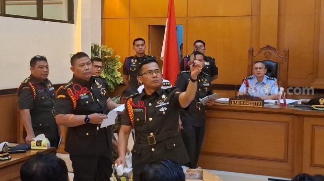 Oditur militer menunjukkan barang bukti pakaian dan kacamata milik korban yang rusak parah akibat siraman air keras, Rabu (6/5/2026). (Suara.com/Yoga)