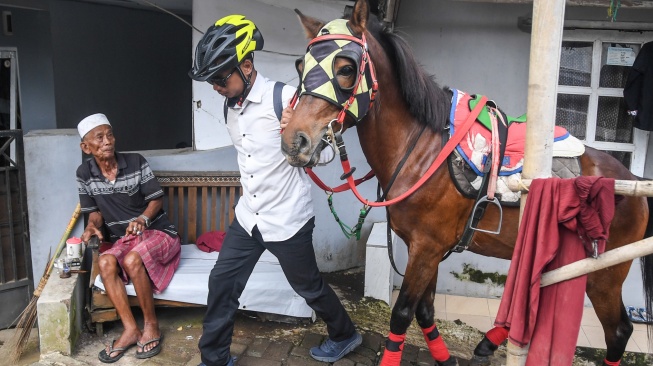 Aparatur Sipil Negara (ASN) Pemerintah Kota Tasikmalaya Mohammad Arif Syamsani bersiap menunggang kuda saat berangkat kerja pada program hari bebas kendaraan bermotor (car free day) di Kota Tasikmalaya, Jawa Barat, Rabu (6/5/2026). [ANTARA FOTO/Adeng Bustomi/bar]