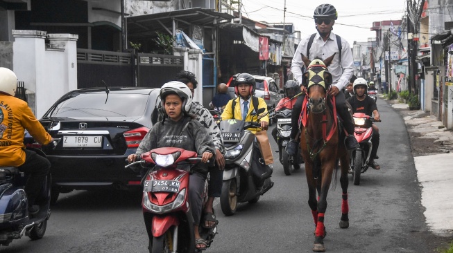 Aparatur Sipil Negara (ASN) Pemerintah Kota Tasikmalaya Mohammad Arif Syamsani menunggang kuda saat berangkat kerja pada program hari bebas kendaraan bermotor (car free day) di Kota Tasikmalaya, Jawa Barat, Rabu (6/5/2026). [ANTARA FOTO/Adeng Bustomi/bar]