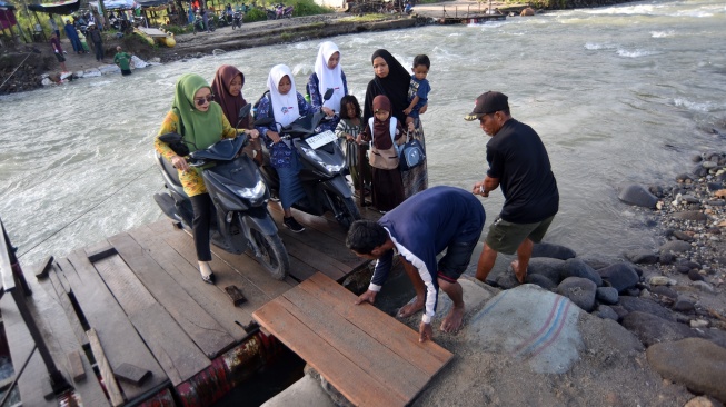 Sejumlah warga dan pelajar bersiap turun dari rakit penyeberangan di Sungai Batang Anai, Nagari Anduriang, Kayu Tanam, Padang Pariaman, Sumatera Barat, Kamis (7/5/2026). [ANTARA FOTO/Fitra Yogi/tom]