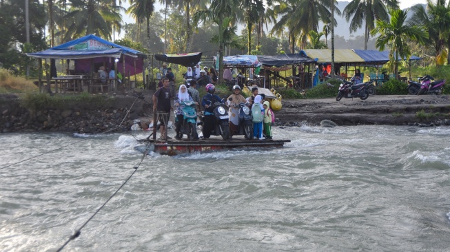 Sejumlah warga dan pelajar menaiki rakit penyeberangan di Sungai Batang Anai, Nagari Anduriang, Kayu Tanam, Padang Pariaman, Sumatera Barat, Kamis (7/5/2026). [ANTARA FOTO/Fitra Yogi/tom]
