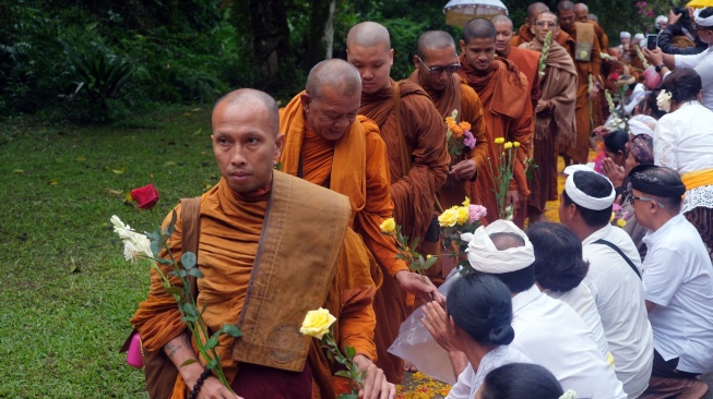 Warga memberikan bunga kepada para Bhikkhu saat Indonesia Walk for Peace 2026 di Pura Siwa Buddha, Tabanan, Bali, Jumat (8/5/2026). [ANTARA FOTO/Nyoman Hendra Wibowo/agr]