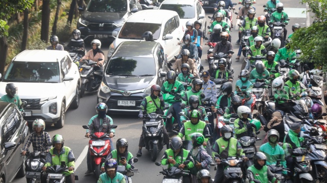 Pengemudi ojek online menunggu penumpang di seberang Stasiun Palmerah, Jakarta, Senin (11/5/2026). [Suara.com/Alfian Winanto]
