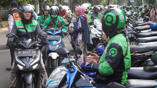 Pengemudi ojek online menunggu penumpang di seberang Stasiun Palmerah, Jakarta, Senin (11/5/2026). [Suara.com/Alfian Winanto]
