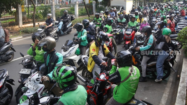 Pengemudi ojek online menunggu penumpang di seberang Stasiun Palmerah, Jakarta, Senin (11/5/2026). [Suara.com/Alfian Winanto]
