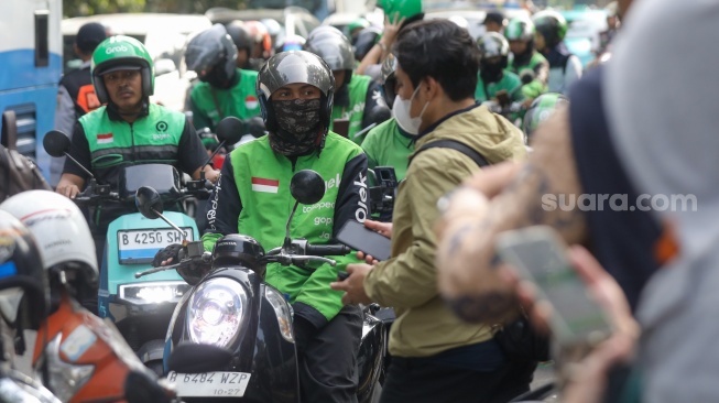Pengemudi ojek online menunggu penumpang di seberang Stasiun Palmerah, Jakarta, Senin (11/5/2026). [Suara.com/Alfian Winanto]
