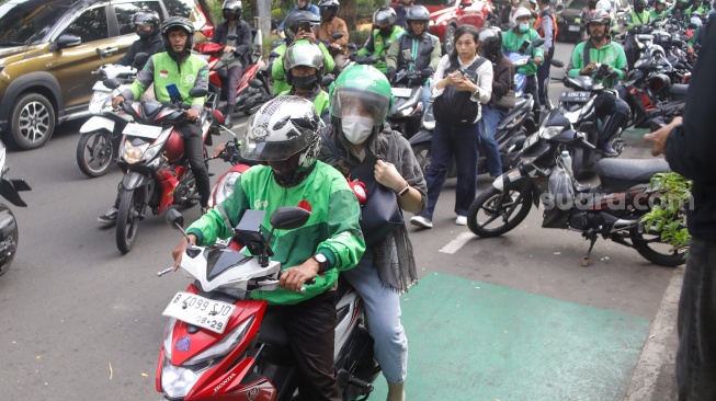 Pengemudi ojek online menunggu penumpang di seberang Stasiun Palmerah, Jakarta, Senin (11/5/2026). [Suara.com/Alfian Winanto]

