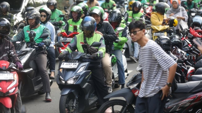 Pengemudi ojek online menunggu penumpang di seberang Stasiun Palmerah, Jakarta, Senin (11/5/2026). [Suara.com/Alfian Winanto]
