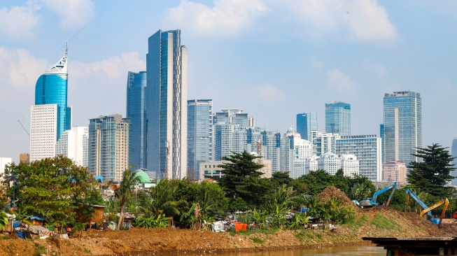Suasana pemukiman penduduk dengan latar belakang gedung bertingkat di Jakarta, Selasa (12/5/2026). [Suara.com/Alfian Winanto]