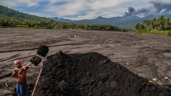Warga menaikkan pasir ke atas truk di area bekas banjir lahar dingin di Desa Mamuya, Kecamatan Galela, Kabupaten Halmahera Utara, Maluku Utara, Selasa (12/5/2026). [ANTARA FOTO/Andri Saputra/sgd]
