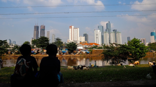 Suasana pemukiman penduduk dengan latar belakang gedung bertingkat di Jakarta, Selasa (12/5/2026). [Suara.com/Alfian Winanto]