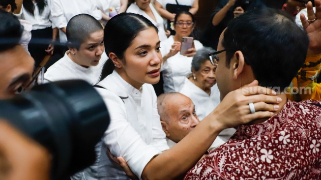Terdakwa kasus dugaan korupsi pengadaan Chromebook dalam program digitalisasi pendidikan di Kemendikbudristek Nadiem Makarim memeluk istrinya Franka Franklin usai menjalani sidang lanjutan di Pengadilan Tipikor, Jakarta, Rabu (13/5/2026). [Suara.com/Alfian Winanto]