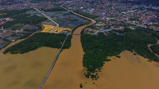Foto udara aliran kali Wanggu dengan kondisi air berwarna cokelat keruh memasuki Teluk Kendari, Kota Kendari, Sulawesi Tenggara, Rabu (13/5/2026). [ANTARA FOTO/Andry Denisah/agr]
