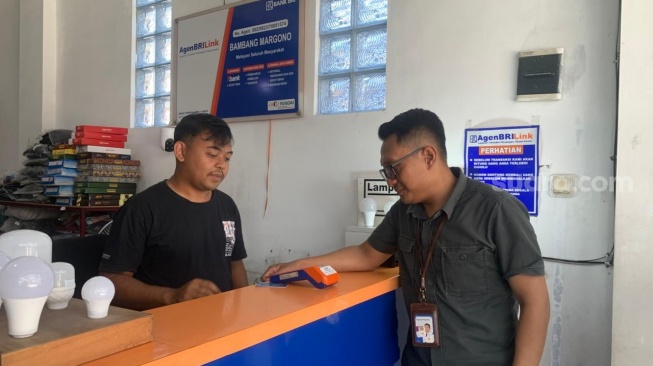 Petugas Penunjang Bisnis Keagenan (PPBK) BRI Cabang Klaten, Sugeng Priyanto, saat meninjau agen BRILink Bambang Margono, Jumat (8/5/2026). (Suara.com/Irwan Febri)