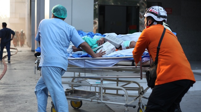 Sejumlah petugas mengevakuasi pasien saat terjadinya kebakaran di gedung Pusat Pelayanan Jantung Terpadu RSUD Dr Soetomo, Surabaya, Jawa Timur, Jumat (15/5/2026). [ANTARA FOTO/Didik Suhartono/hma]