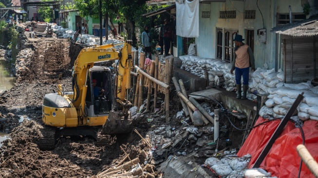 Pekerja Dinas Pekerjaan Umum Kota Semarang menggunakan alat berat untuk memperbaiki struktur Jalan Jembawan 1 yang amblas di kawasan Kalibanteng Kulon, Semarang, Jawa Tengah, Senin (18/5/2026). [ANTARA FOTO/Aprillio Akbar/bar]