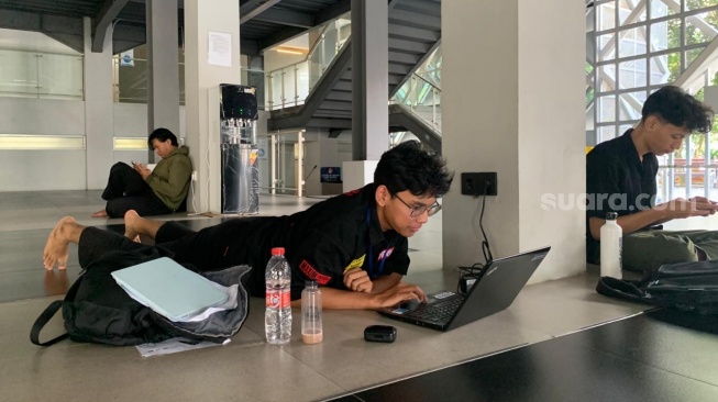 Mahasiswa Teknik Kimia, Muhammad Hanief, yang mengerjakan tugas di Masjid Al-Mustadam. (Suara.com/Irwan Febri)