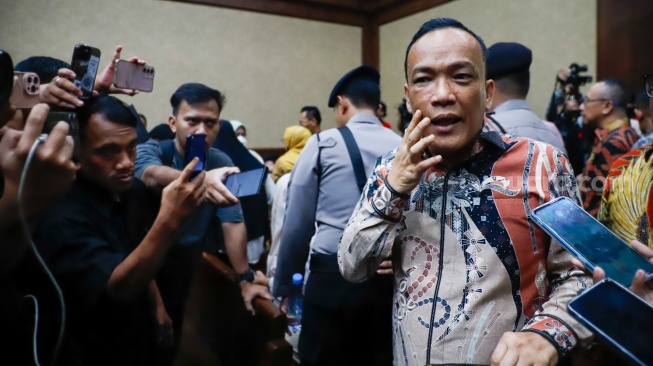 Terdakwa kasus dugaan pemerasan dalam pengurusan sertifikat Keselamatan dan Kesehatan Kerja (K3) di Kementerian Ketenagakerjaan Immanuel Ebenezer menunjukan luka lebam akibat sakit gigi saat bersiap mengikuti sidang lanjutan di Pengadilan Tipikor, Jakarta, Senin (18/5/2026). [Suara.com/Alfian Winanto]