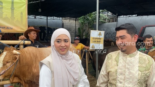 Ustaz Solmed dan April Jasmine saat meninjau tempat pembelian sapi kurban di kawasan Bekasi, Jawa Barat pada Selasa, 19 April 2026 [Suara.com/.Tiara Rosana]