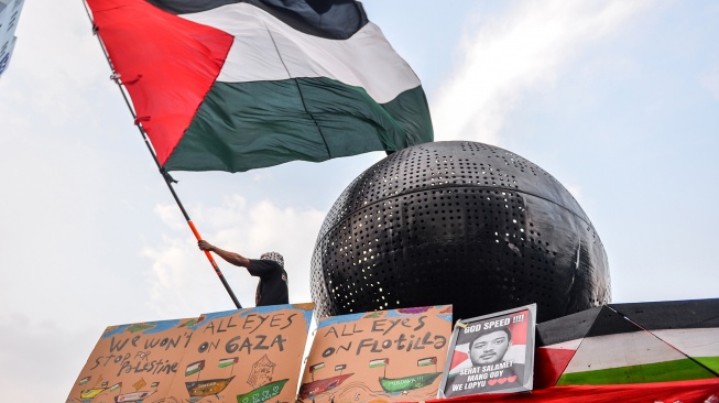 Massa dari Solidaritas Seni untuk Palestina mengibarkan bendera Palestina saat mengikuti aksi solidaritas bagi WNI dan Jurnalis yang diculik Israel di Jalan Asia Afrika, Bandung, Jawa Barat, Selasa (19/5/2026). [ANTARA FOTO/Raisan Al Farisi/YU]