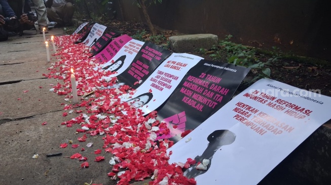 Aliansi Perempuan Indonesia membawa sejumlah poster saat aksi di depan Gedung Komnas HAM, Menteng, Jakarta Pusat, Selasa (19/5/2026). (Suara.com/Cornelius Juan Prawira)