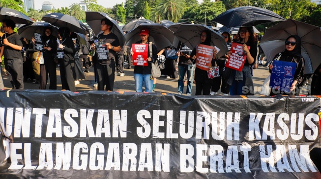 Pegiat HAM yang tergabung dalam Jaringan Solidaritas Korban untuk saat mengikuti aksi kamisan ke-908 di seberang Istana Merdeka, Jakarta, Kamis (21/5/2026). [Suara.com/Alfian Winanto]
