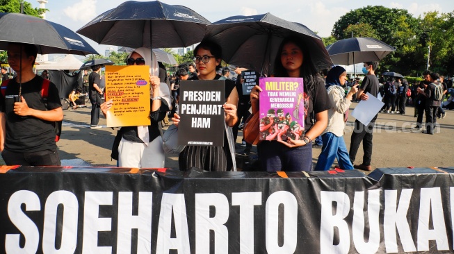 Pegiat HAM yang tergabung dalam Jaringan Solidaritas Korban untuk saat mengikuti aksi kamisan ke-908 di seberang Istana Merdeka, Jakarta, Kamis (21/5/2026). [Suara.com/Alfian Winanto]
