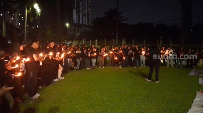 Aksi massa "#Reformati" yang dihadiri mahasiswa UI dengan pakaian bernuansa hitam sambil membawa lilin yang menyala di depan Tugu Makara pada Rabu (20/5/2026). (Suara.com/ Cornelius Juan Prawira)
