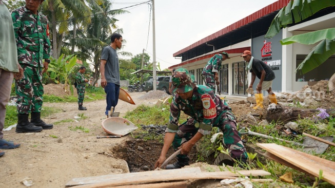 Satgs TMMD ke-128 Kodim 0623/Cilegon sedang melakukan pengerjaan sasaran fisik di Kecamatan Pulomerok, Kota Cilegon. [Hairul Alwan/Suara.com]