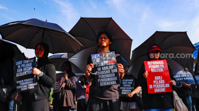 Pegiat HAM yang tergabung dalam Jaringan Solidaritas Korban untuk saat mengikuti aksi kamisan ke-908 di seberang Istana Merdeka, Jakarta, Kamis (21/5/2026). [Suara.com/Alfian Winanto]
