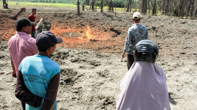 Warga mengamati sumur bor yang menyemburkan api dari dalam tanah di area perkebunan kelapa sawit Desa Blang Rubek, Kecamatan Lhoksukon, Aceh Utara, Aceh, Jumat (22/5/2026). [ANTARA FOTO/Rahmad/tom]