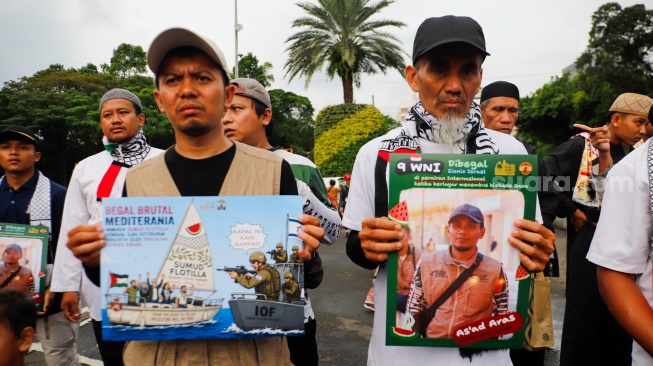 Massa yang berasal dari Aliansi kemanusiaan Aqsa Working Group (AWG) membawa poster bertema penculikan aktivis oleh zionis saat Aksi Jumat untuk Palestina di depan Kedutaan Besar Amerika Serikat, Jakarta, Jumat (22/5/2026). [Suara.com/Alfian Winanto]
