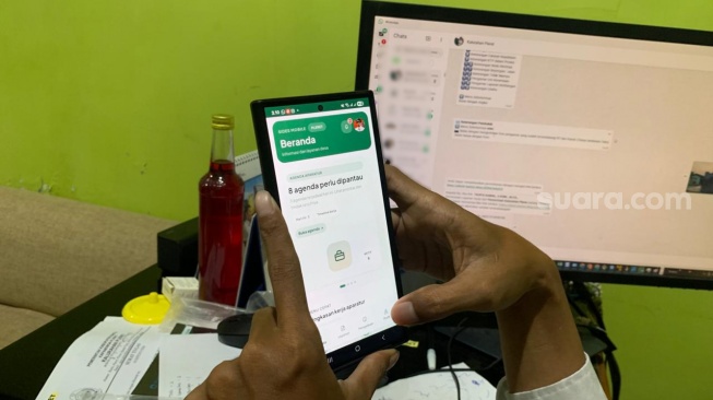 Lurah Pleret, Taufiq Kamal, ketika menunjukkan sistem aplikasi kalurahan yang juga sudah mobile friendly, sehingga tetap bisa memberikan pelayanan meski tidak sedang di kantor. (Suara.com/Irwan Febri)